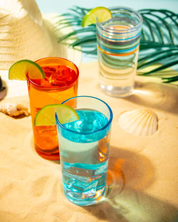 Summer non alcoholic cocktails in colorful glasses on beach with white sand. Summer sea ocean vacation and travel concept. Beach party.の写真素材