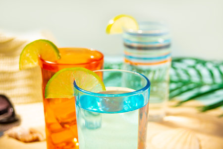 Summer alcoholic cocktails with lime in colorful glasses on the beach with white sand. Summer sea ocean vacation and travel concept. beach partyの写真素材