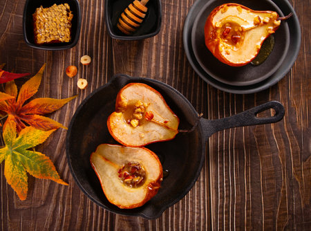 Honey or maple syrup roast pears with walnuts on wooden background. Vegetarian diet health delicious dessert. top view. copyspace.の写真素材