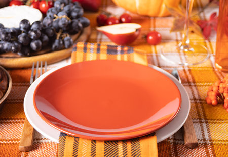 Autumn place setting dinner for celebration Thanksgiving Day. holiday party. Festive table. Snacks, friuts, pie, pumpkin, vegetables, wine glassesの写真素材