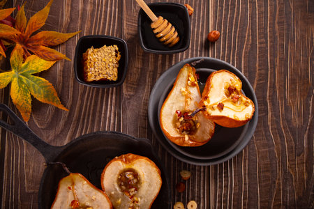 Honey or maple syrup roast pears with walnuts on wooden background. Vegetarian diet health delicious dessert. top view. copyspace.の写真素材