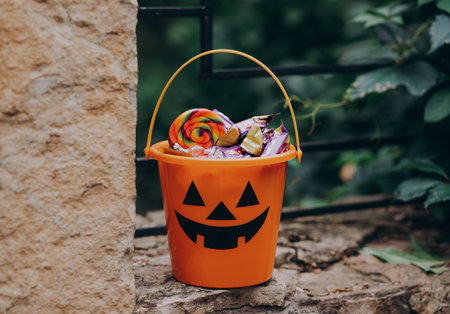 Halloween Jack o Lantern orange bucket with candy treats outdoor.の写真素材