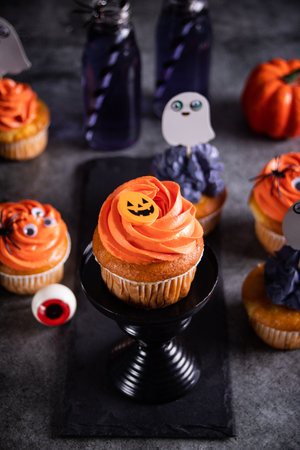 Festive Halloween cupcakes with whipped orange cream decorated candy pumpkin. Party celebration concept.の写真素材