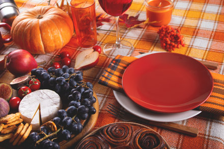 Autumn place setting dinner for celebration Thanksgiving Day. holiday party. Festive table. Snacks, friuts, pie, pumpkin, vegetables, wine glassesの写真素材
