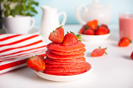 Pink red stack tasty homemade pancakes with fresh strawberries. Breakfast for two. Valentines day...