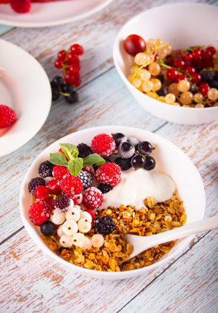 Granola, muesli cereals with yogurt or milk and fresh berries. healthy breakfast conceptの写真素材