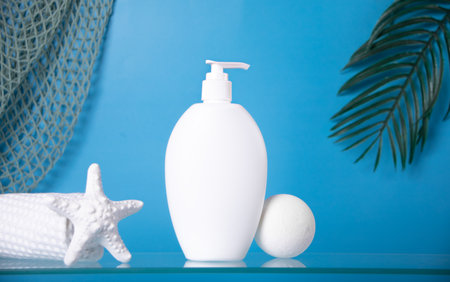 Blank mock up bottle beauty cosmetic skin care organic product for bathing routine with bath salt on blue background with sea shell and palm leaf. Place your design.の写真素材