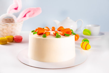 Cake with cream cheese frosting for Easter decorated carrots. Festive table.の写真素材