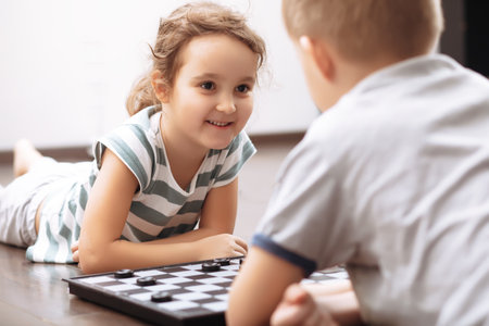 Teenager boy and little girl play chess.の写真素材