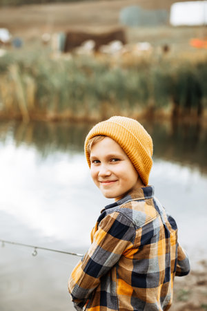 Kid teen boy catching a fish on the lake, river or pond.の写真素材