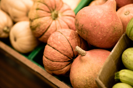 Pumpkins on fruit stand in supermarket or farmer shop. Organic vegetables for sale on display....