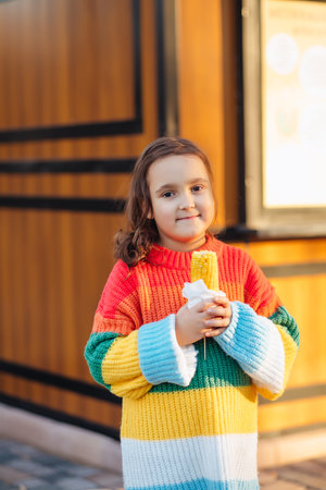 Caucasian little cute girl eating delicious tasty corn on the cobの写真素材