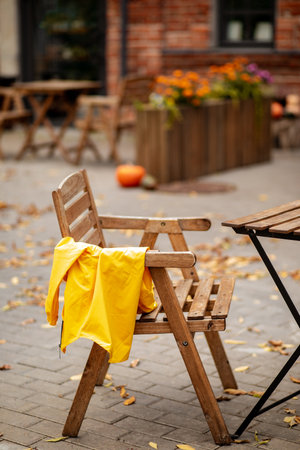 Cafe patio with empty wooden table and chair is set up in a autumn decoration with pumpkins, leaves and flowers. Fall aesthetic.の写真素材