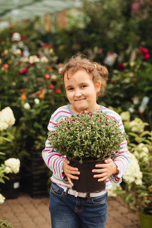 Little cute girl buying flowers in market. Choosing plants in a local garden centerの写真素材