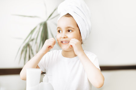 Cute little girl use dental floss at home. Morning routineの写真素材