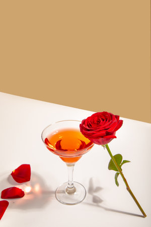 Glass of red wine with red rose on the white background. Romantic date conceptの写真素材