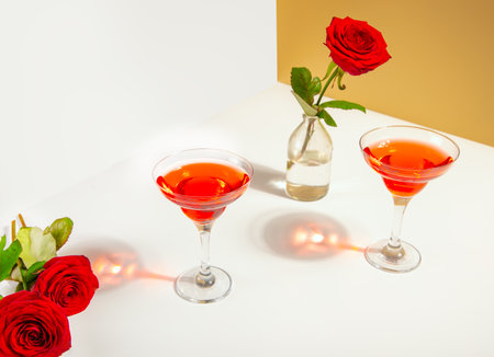 Glasses of red wine with red rose on the white background. Romantic date conceptの写真素材