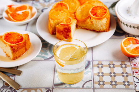 Glass of fresh lemonade and orange cake with fruit citrus slicesの写真素材