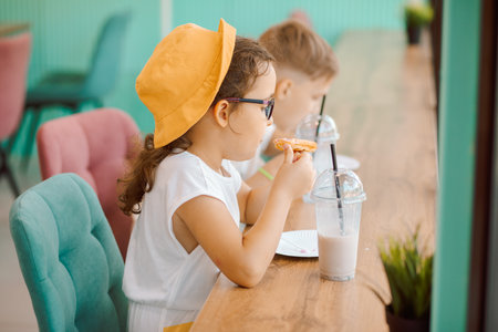 Cute girl and teenager boy eat with ice cream and drinking milkshake in cafe and having fun. Retro styleの写真素材