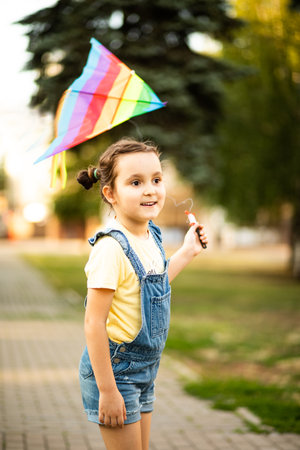 Little cute girl running with kite on summer day in the park outdoor. Summer outdoor activityの写真素材