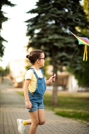 Little cute girl running with kite on summer day in the park outdoor. Summer outdoor activityの写真素材