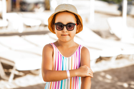 Cute little girl applying sunscreen at the beach in summer. Holiday vacation with childrenの写真素材