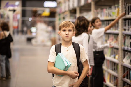 Cute teenager kid boy choosing school stationery in supermarket.の写真素材