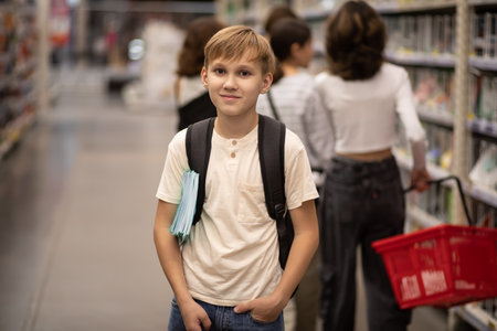 Cute teenager kid boy choosing school stationery in supermarket.の写真素材