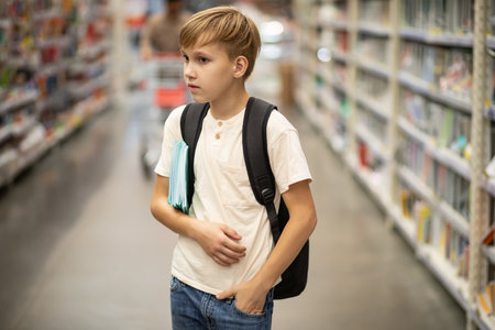 Cute teenager kid boy choosing school stationery in supermarket.の写真素材