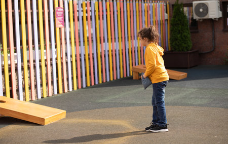 Cute little girl playing Corn hole bag toss game in a park outdoor.の写真素材
