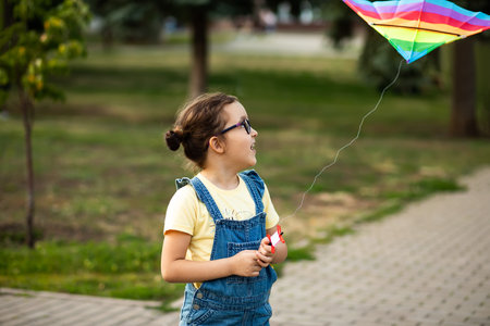 Little cute girl running with kite on summer day in the park outdoor. Summer outdoor activityの写真素材