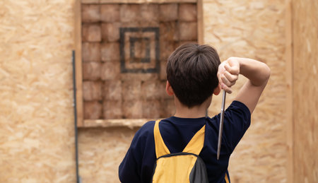 Kid boy is ready for throwing knife to the target.の写真素材