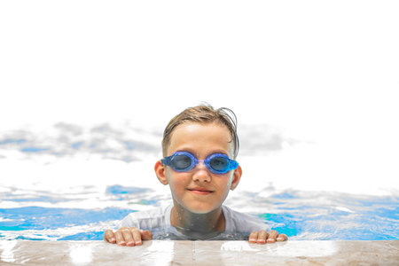 Happy kid boy playing in outdoor swimming pool at sunny day. Active vacation and healthy lifestyle. Happy summertimeの写真素材