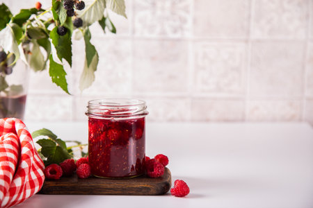 Homemade raspberry jam with fresh berries.