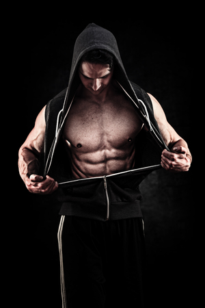 Muscular and fit young bodybuilder fitness male model posing grunge backgroundの写真素材
