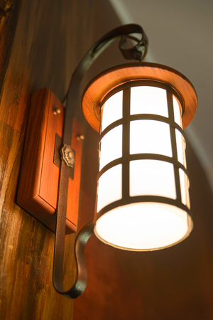 Old steel wall lamp on wooden wallの写真素材