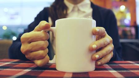 woman drinking a hot drink in cafeの写真素材