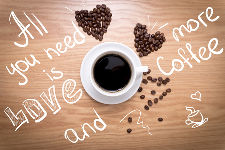 Hot cup of espresso and heart shape made from coffee beans with sing.の写真素材