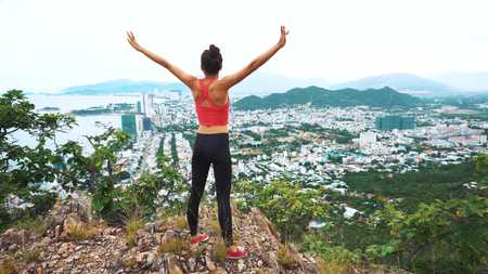 Woman runner raise hands up in the air. Female cheering in winning gesture.の写真素材