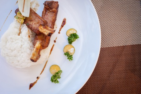 Hot Meat Dishes - BBQ Ribs with Tomatoes and Spicy Sauce with rise and limeの写真素材