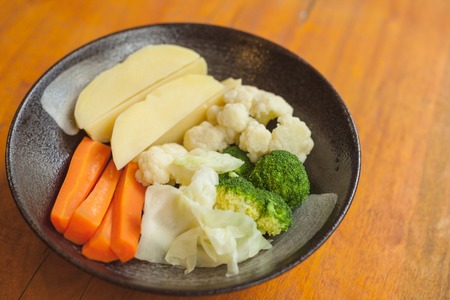 Steamed vegetables in black plateの写真素材