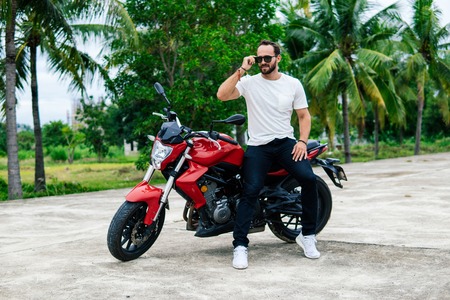Biker standing near his motocycleの写真素材