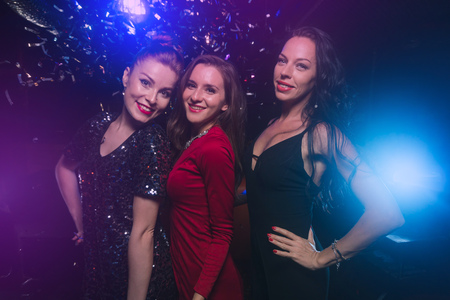 Three female friends have fun together on celebration partyの写真素材
