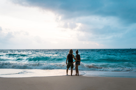 Couple hugging and enjoying ocean view at beachの写真素材