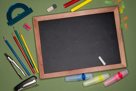 School concept. Empty chalk board, stationery on green background, copy space.の写真素材