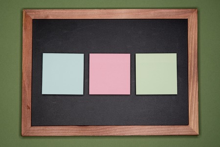 Sticky notes on chalkboard on green background, blank copy space