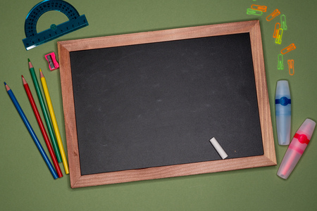 School concept. Empty blackboard, stationery on green background, copy space.の写真素材