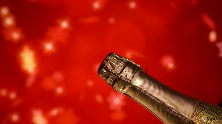 Champagne bottle. Holiday red blinking background. Party celebrating.の写真素材