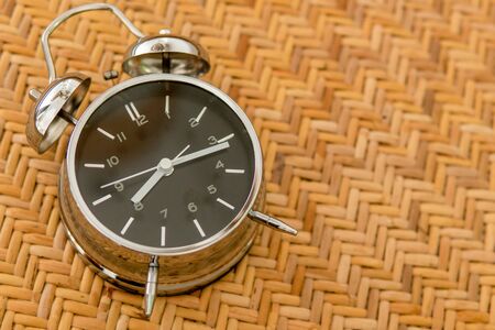Alarm clock on braided texture. Start work concept.の写真素材
