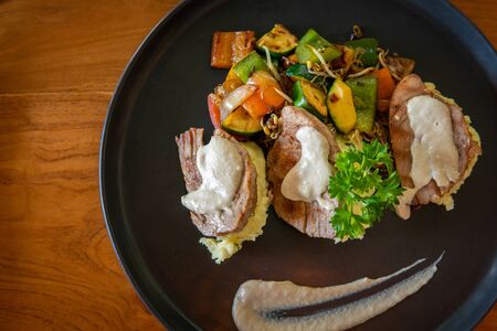 Fish dish with red tuna steak on mashed potatoes with grilled vegetables.の写真素材
